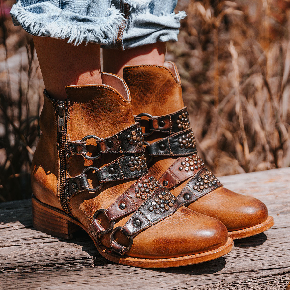 FREEBIRD women's Grady tan leather bootie with an inside working zipper, low bock heel and abstract shaft belt detailing