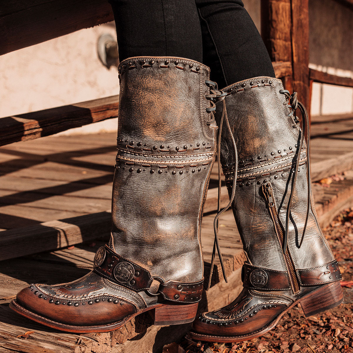 FREEBIRD women's Gynger ice leather boot with a harness belt, stud embellishments and signature stitching