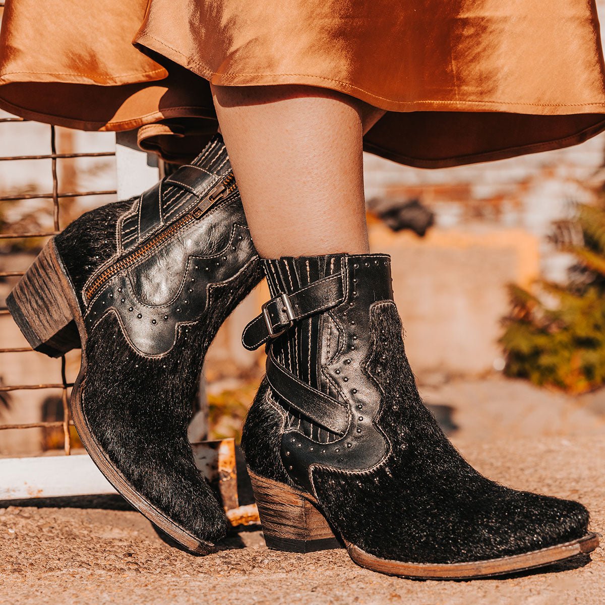 FREEBIRD women's Morgan black pony multi leather ankle bootie with silver stud embellishments, gore detailing, and buckle straps 