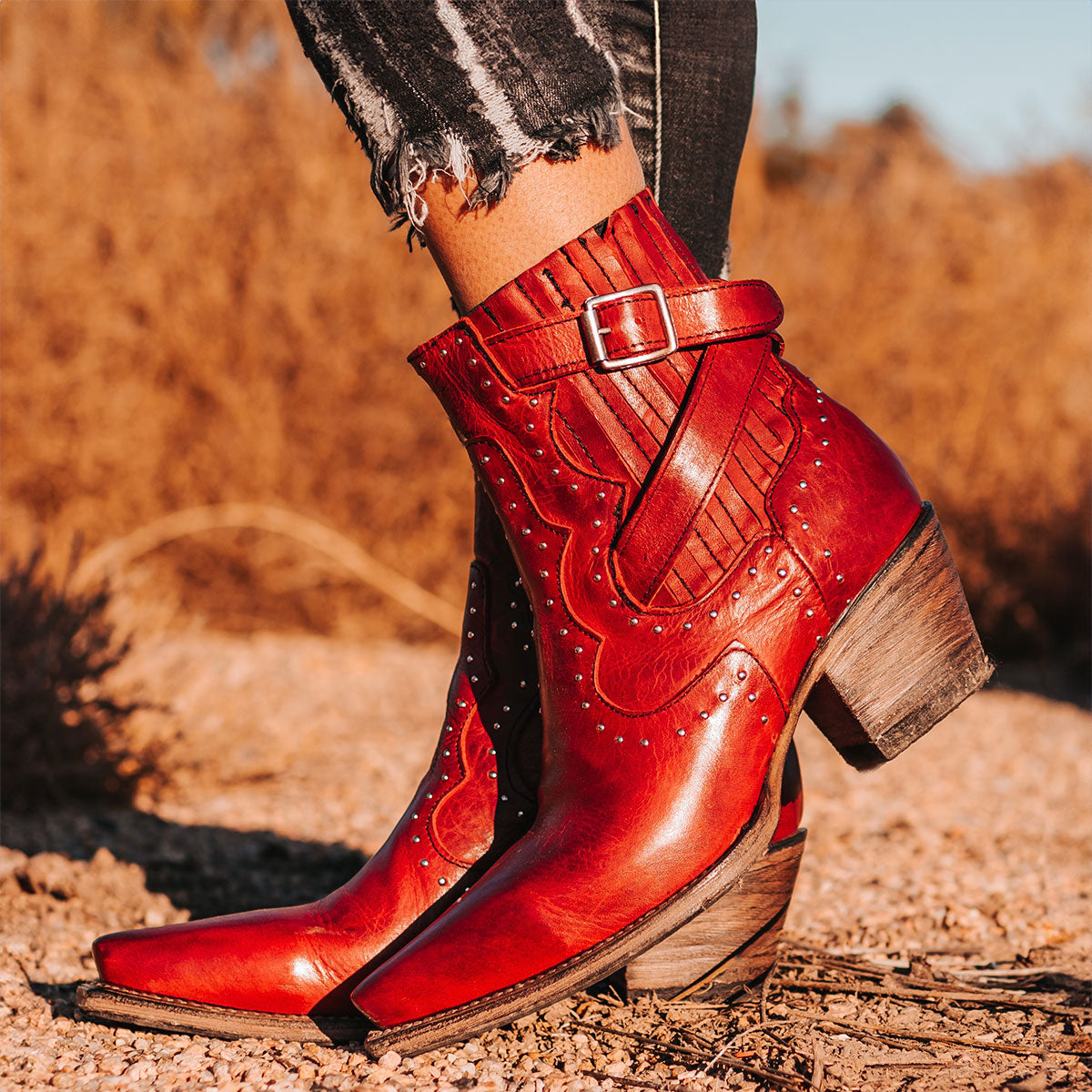 FREEBIRD women's Morgan red leather ankle bootie with silver stud embellishments, gore detailing, and buckle straps