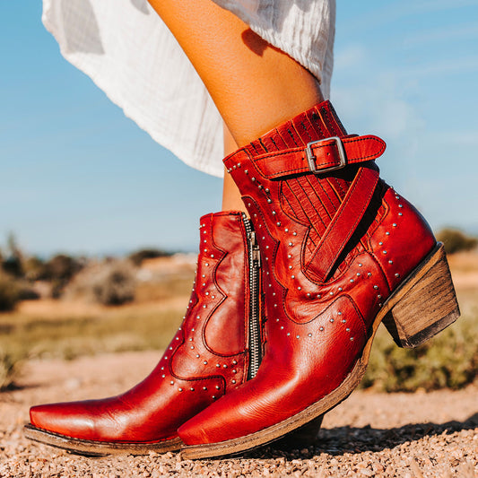 FREEBIRD women's Morgan red leather ankle bootie with silver stud embellishments, gore detailing, and buckle straps