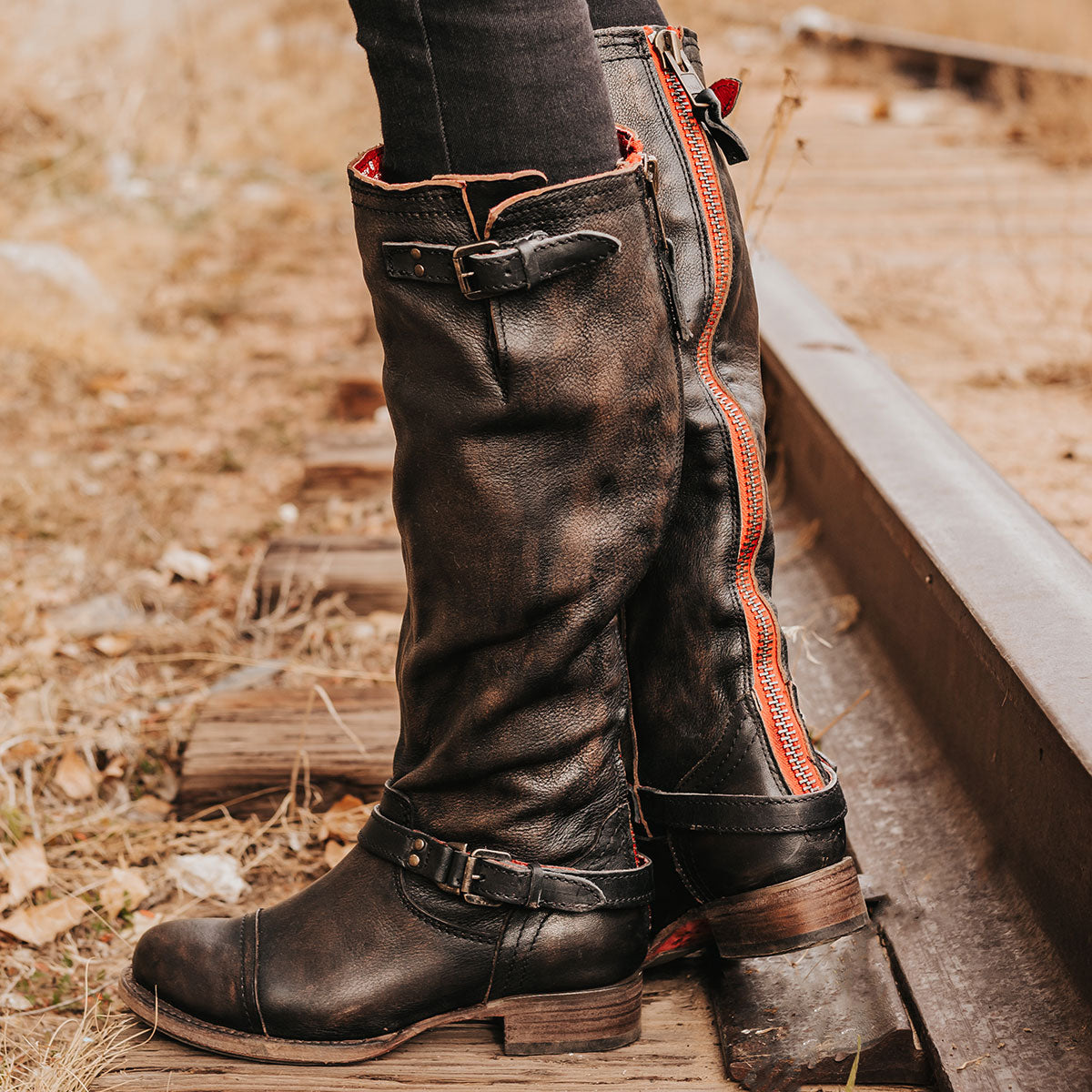 FREEBIRD women's Roadey black tall construction boot with double buckle detailing and signature red tracked zipper 